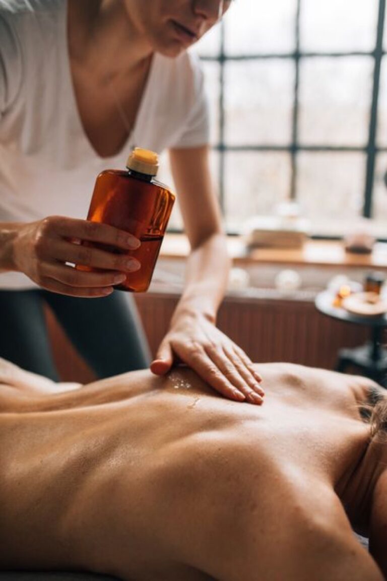 Terapeuta aplicando aceite para un masaje de espalda